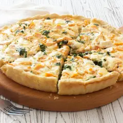 Pyszna tarta z łososiem, szpinakiem i serem feta, pokrojona na kawałki, gotowa do podania.