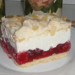 Malinowa chmurka na białym talerzu, z warstwą biszkoptu, galaretki malinowej, kremu i bezy z migdałami.