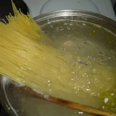 Długi makaron spaghetti gotuje się w bulgoczącej wodzie. Czas, ile gotować makaron, zależy od jego grubości.