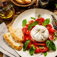 Pyszna burrata co to? Kremowy ser z pomidorami, bazylią i chrupiącym pieczywem. Idealna na lekki posiłek.