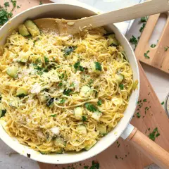 Pyszny makaron z cukinią, posypany parmezanem i świeżą natką pietruszki, gotowy do podania.