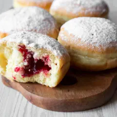 Puszyste pączki z dżemem, posypane cukrem pudrem. Idealne na tłusty czwartek, zgodnie z tradycyjnym paczki przepis.