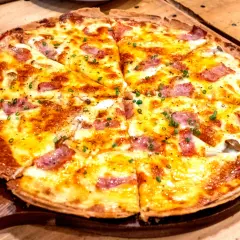 Pyszna pizza z patelni bez drożdży, z ciągnącym serem, kawałkami boczku i szczypiorkiem. Idealna na szybki obiad.