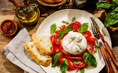 Pyszna burrata co to? Kremowy ser z pomidorami, bazylią i chrupiącym pieczywem. Idealna na lekki posiłek.