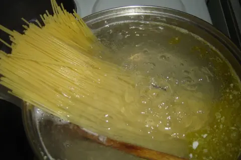 Długi makaron spaghetti gotuje się w bulgoczącej wodzie. Czas, ile gotować makaron, zależy od jego grubości.