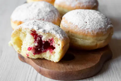 Puszyste pączki z dżemem, posypane cukrem pudrem. Idealne na tłusty czwartek, zgodnie z tradycyjnym paczki przepis.