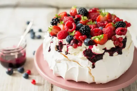 Beza Pavlova z owocami leśnymi i polewą. Idealny przepis na letni deser.