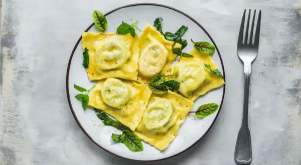 Pyszne ravioli z zielonym nadzieniem, udekorowane listkami. Idealny przepis na ravioli dla każdego smakosza.