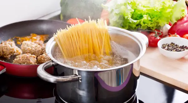 Gotujesz spaghetti? Aby makaron się nie sklejał, dodaj łyżkę oleju do wrzącej wody. Obok smażą się klopsiki.