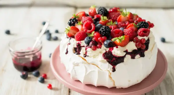 Beza Pavlova z owocami leśnymi i polewą. Idealny przepis na letni deser.