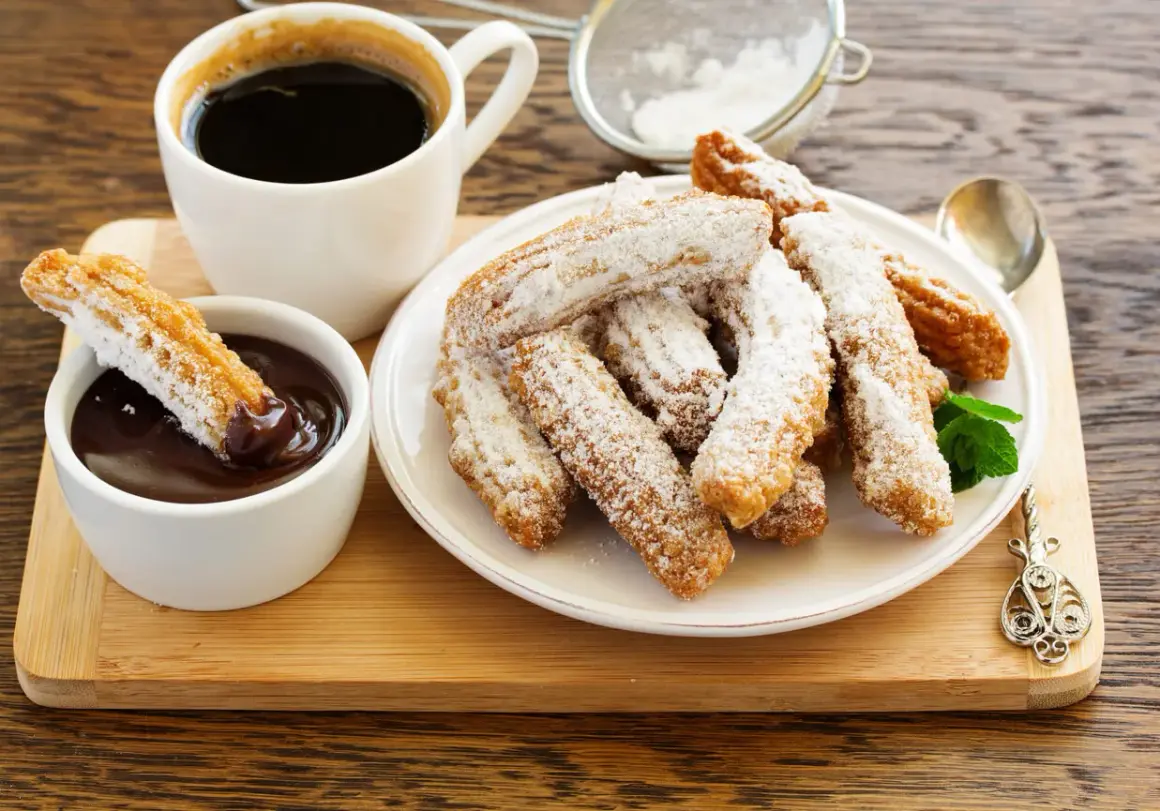 Churros przepis: złociste, posypane cukrem pudrem, z gorącą czekoladą i kawą. Idealne na deser.
