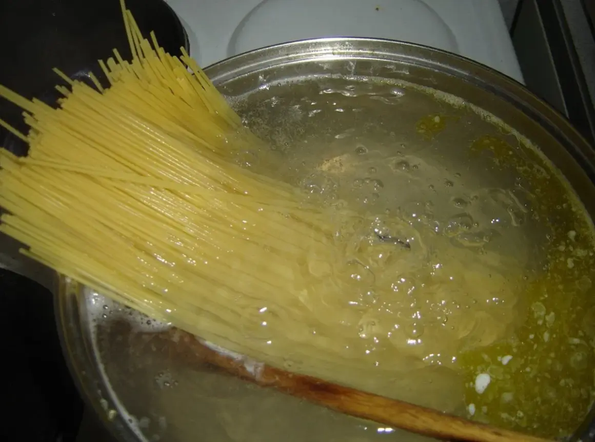Długi makaron spaghetti gotuje się w bulgoczącej wodzie. Czas, ile gotować makaron, zależy od jego grubości.