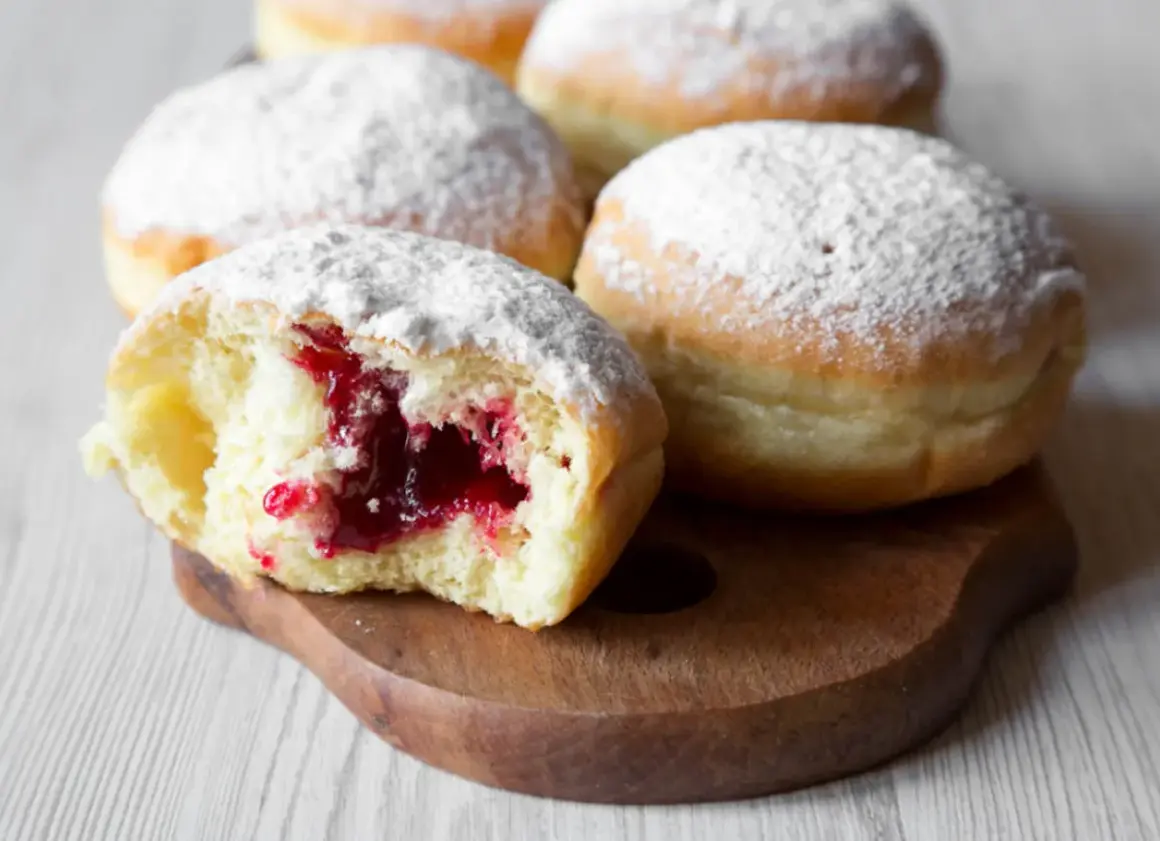 Puszyste pączki z dżemem, posypane cukrem pudrem. Idealne na tłusty czwartek, zgodnie z tradycyjnym paczki przepis.