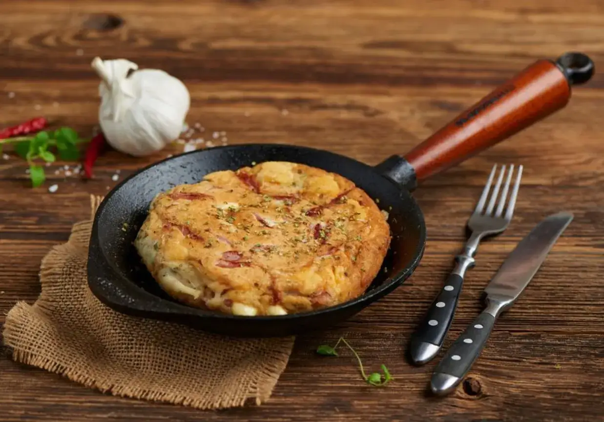 Pyszny omlet z szynką i serem w patelni, gotowy do podania. Idealny przepis na śniadanie, jak zrobić omlet z szynką i serem.