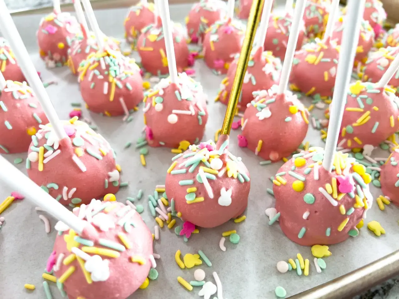 R&oacute;żowe cake pops z kolorową posypką i kr&oacute;liczkami, idealne na Wielkanoc. Prosty cake pops przepis na słodką przekąskę.