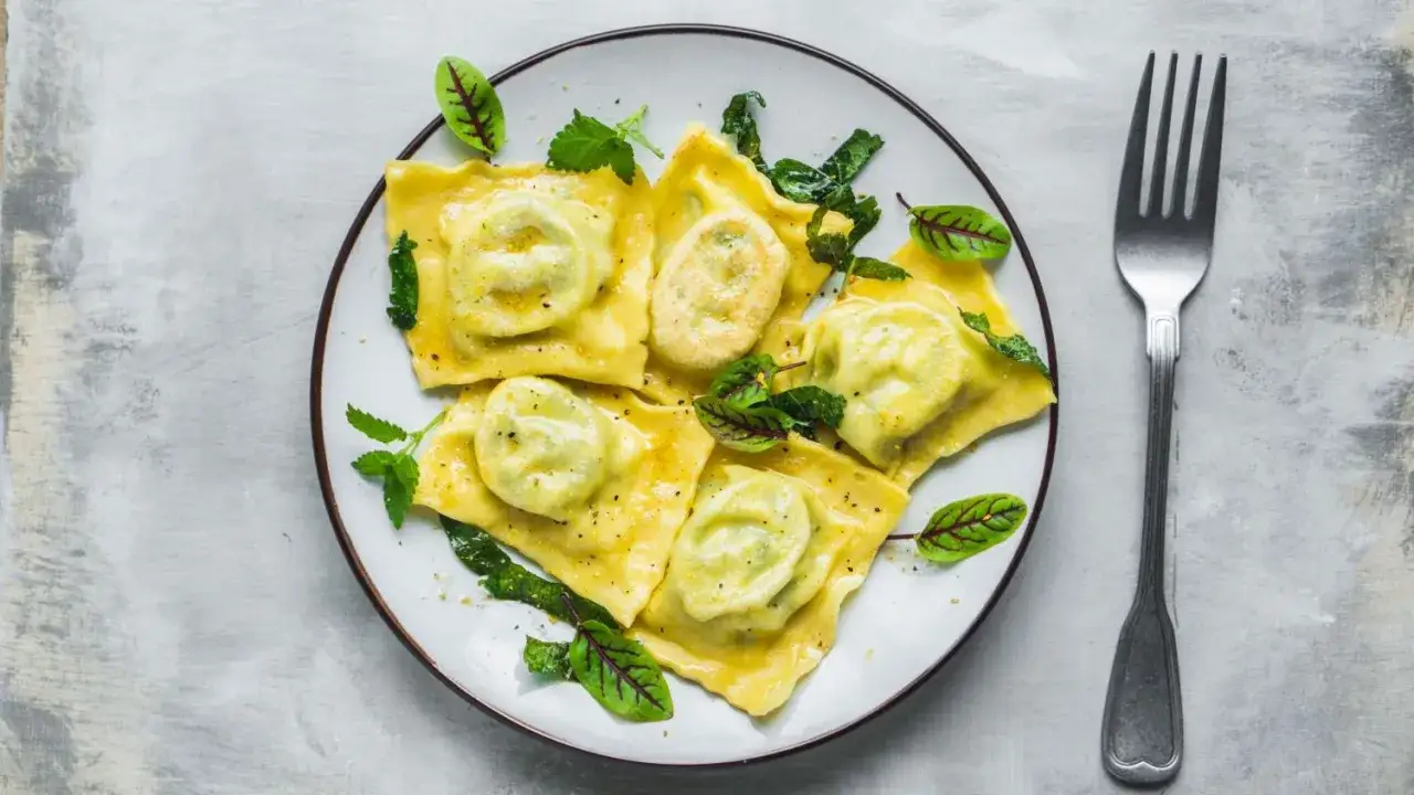 Pyszne ravioli z zielonym nadzieniem, udekorowane listkami. Idealny przepis na ravioli dla każdego.