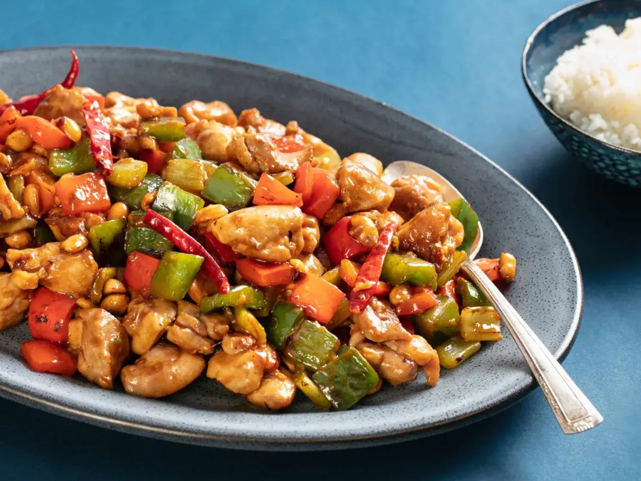 Pyszny kurczak po azjatycku z orzeszkami ziemnymi, papryką i chili na talerzu.