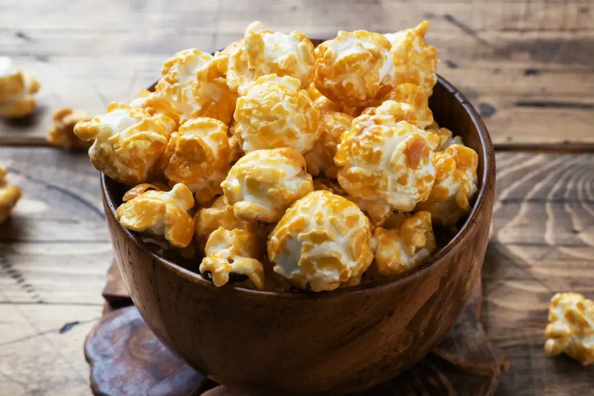 Pyszny, karmelowy popcorn w drewnianej misce. Idealny, gdy zastanawiasz się, jak zrobić popcorn w garnku.