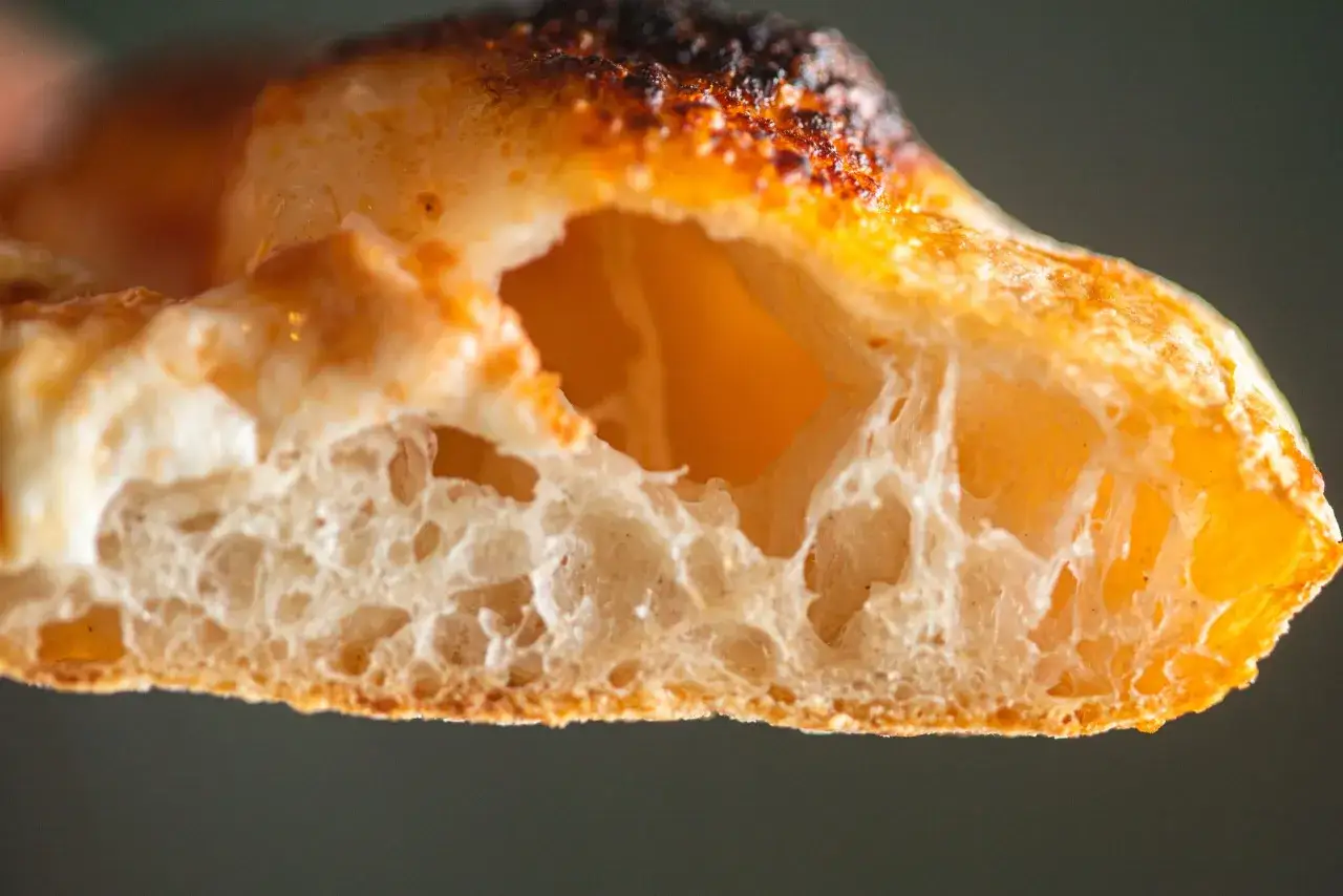 Puszyste ciasto na pizzę z chrupiącą sk&oacute;rką i widocznymi pęcherzykami powietrza. Idealne do domowej pizzy.