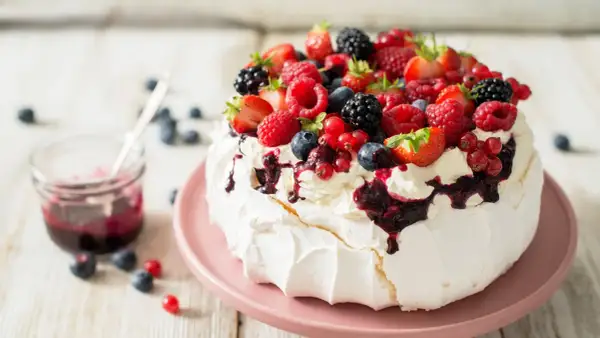 Beza Pavlova z owocami leśnymi i polewą. Idealny przepis na letni deser.